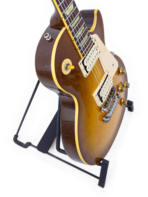 1998 Gibson Les Paul Classic 1960 Reissue guitar displayed on a stand, set against a minimalist white backdrop.