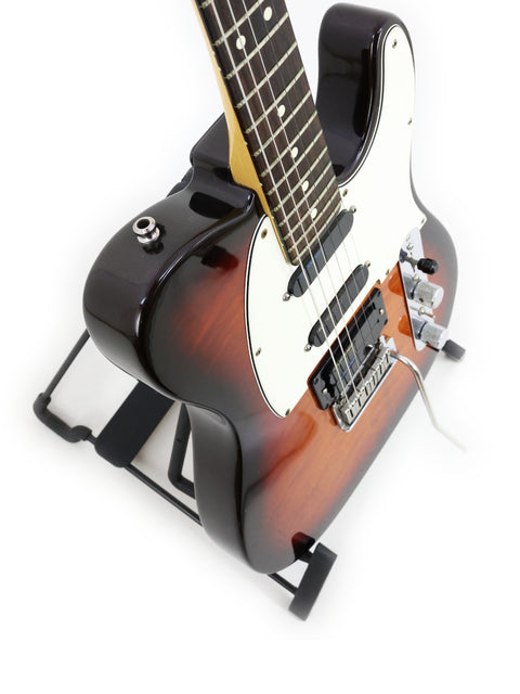 A 1992 Fender Telecaster Plus Deluxe guitar displayed on a stand, highlighting its iconic shape and vintage appeal.