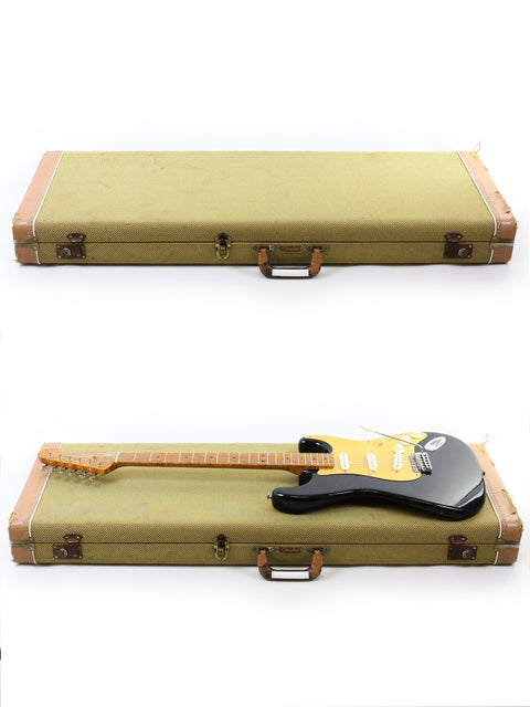 A Fender AVRI ‘56 Stratocaster and another guitar displayed in a case on a pristine white background.