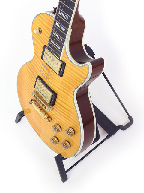 A Gibson Les Paul Supreme guitar on a stand, set against a clean white background, showcasing its elegant design.
