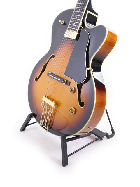 A Yamaha AEX1500 guitar, produced in Japan in 2004, elegantly positioned on a stand with a pure white background.