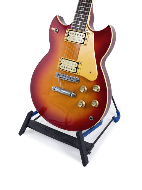 A classic 1981 Yamaha SG 800S guitar in red, elegantly positioned on a stand for all to admire.