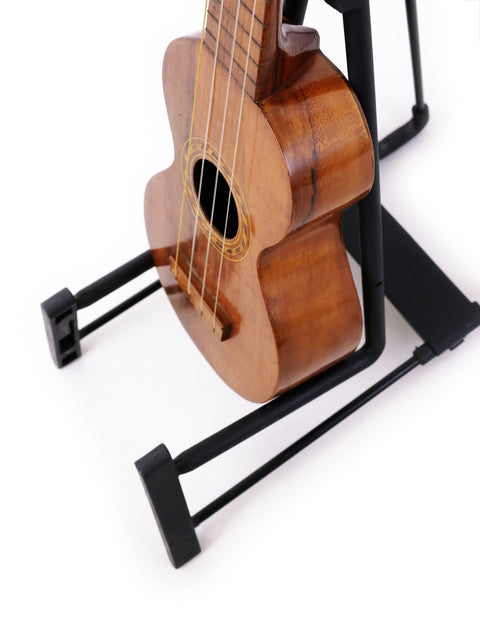 A historic Kumalae Style 2 ukulele, dating back to 1913, displayed on a stand, highlighting its unique Hawaiian design.