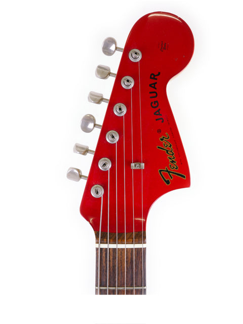A striking red Fender CIJ Jaguar guitar, complete with a red headstock and neck, highlighting its unique design from Japan.