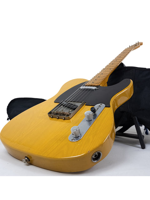 A striking yellow guitar, the Fender Squier JV Telecaster, nestled in a black case, representing its 1984 reissue.