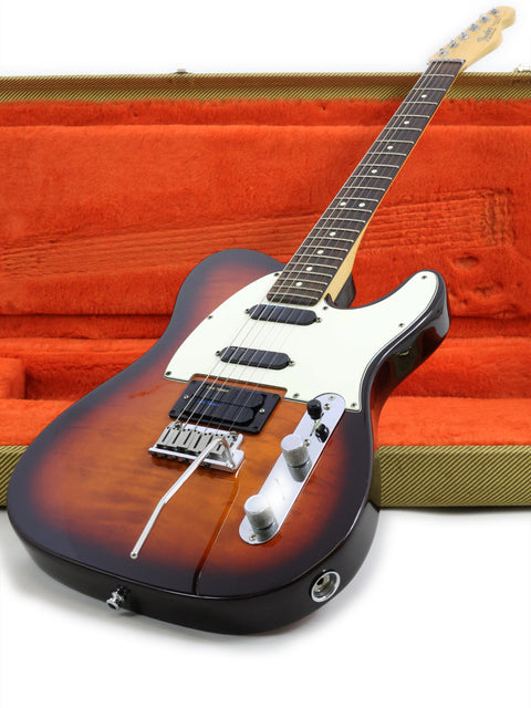 A vibrant orange case encases a Fender Telecaster Plus Deluxe guitar, emphasizing its iconic design and rich history.