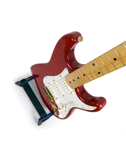 A vibrant red electric guitar, the Fender MIJ '57 Style Stratocaster from 1992, featuring a striking white pick guard.