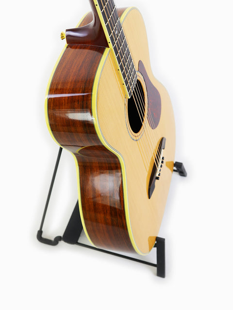 Alvarez Yairi FYM95V guitar displayed on a stand, with a simple white backdrop that accentuates its stunning features.