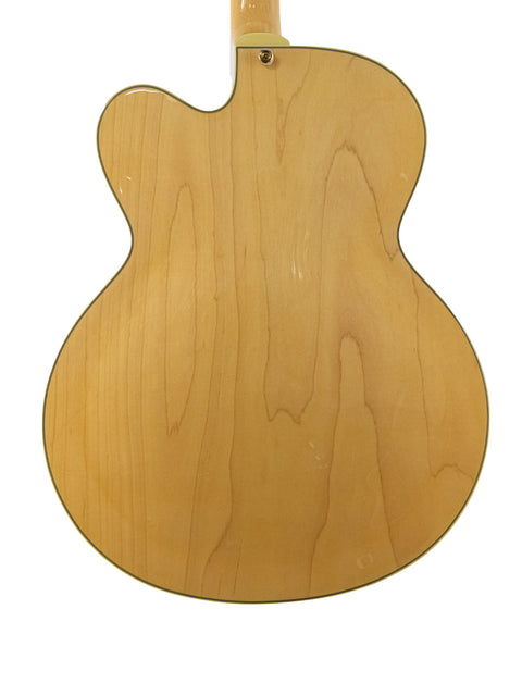 An Epiphone Coronet guitar from 1965, highlighting its wooden back and neck, embodying vintage craftsmanship.