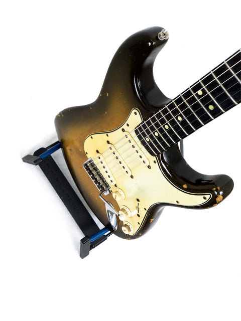 Classic 1963 L Series Stratocaster guitar with a rich brown body and contrasting black pick guard, a true vintage piece.