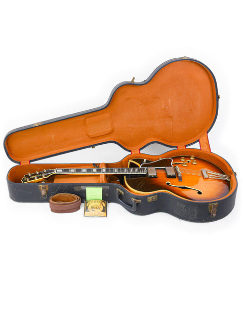Classic 1966 Gibson Byrdland guitar with a protective case and a guitar pick, representing timeless musical artistry.