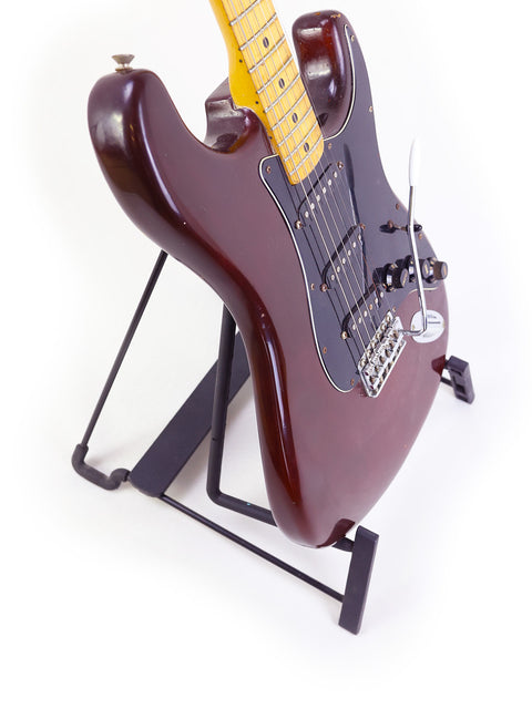 Classic 1979 Fender Stratocaster guitar on a stand, featuring a stark white background.