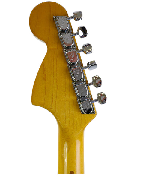 Close-up of a 1981 Fender Stratocaster guitar head, featuring a vibrant yellow body that captures its vintage charm.