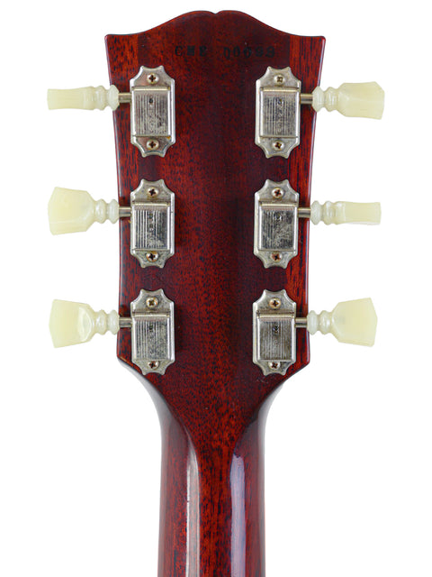 Close-up of a Gibson Custom Shop '64 SG Standard headstock with four knobs, highlighting its vintage aesthetic and quality.