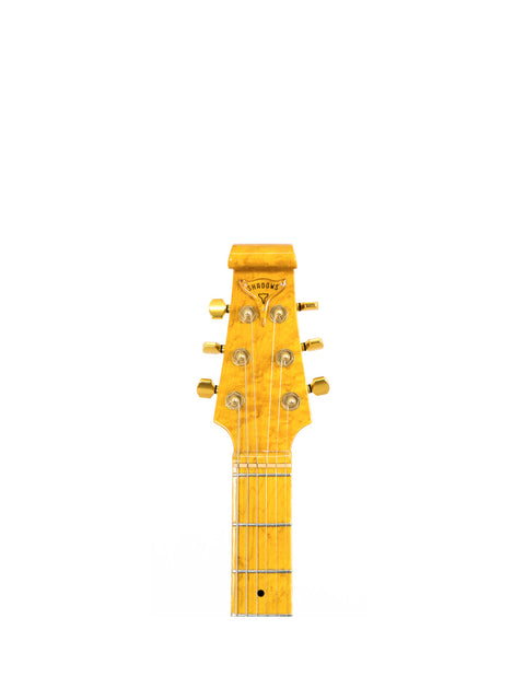 Close-up of a guitar headstock against a white background.