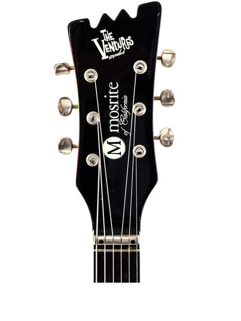 Detailed view of a 1990s Mosrite Of California guitar headstock, featuring the Vanguard music logo and classic design.