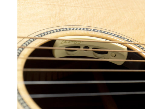 Detailed view of a Breedlove Journey Concert Ltd acoustic guitar with a pick, highlighting its unique Sitka and Brazilian wood.