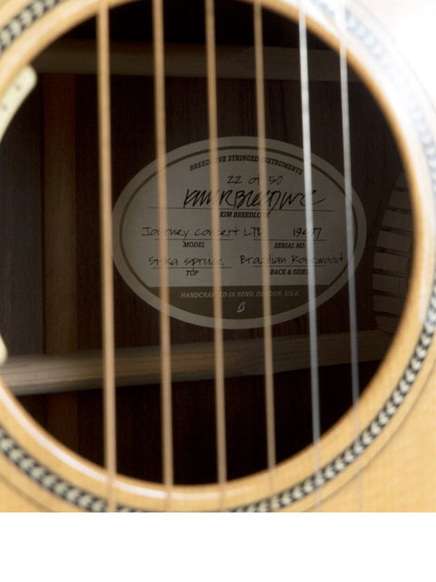 Detailed view of an acoustic guitar showcasing a label: "Breedlove Journey Concert Ltd Sitka / Brazilian #22 of 50 – USA 2016."