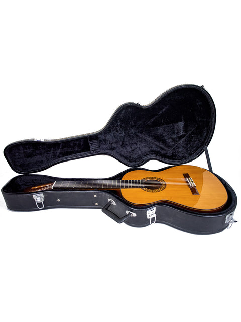 Inside a sleek black guitar case rests an Alhambra C-Series ORO Classical Guitar, crafted in Spain in 2005.