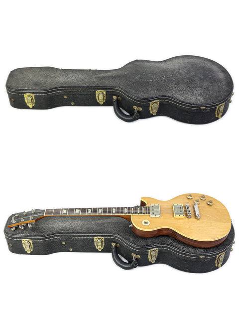 Inside a wooden case, two guitars are displayed, one being a vintage 1973 Gibson Les Paul Deluxe Refinish.