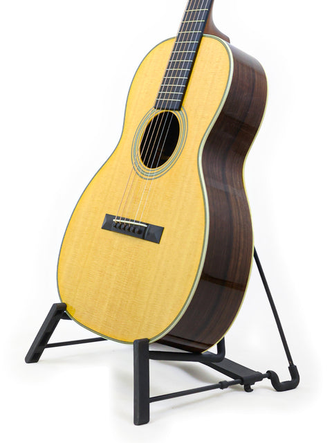 Martin 00-28VS guitar displayed on a stand, set against a simple white backdrop, highlighting its craftsmanship.