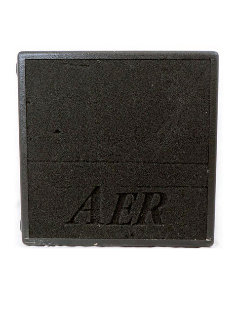 Rear view of the AER Bass Cube 2 amplifier with textured black casing and AER logo engraved.