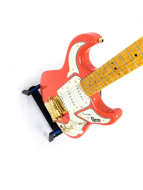 Red electric guitar on a white background with visible brand name.