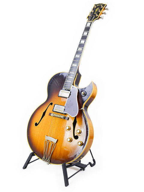 Vintage 1966 Gibson Byrdland guitar elegantly positioned on a stand with a crisp white background.