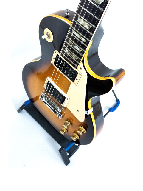 Vintage 1973 Gibson Les Paul Standard guitar, characterized by its black body and distinctive yellow neck.