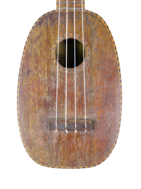 Vintage Kamaka Pineapple Ukulele from 1930, featuring a wooden body and neck, showcasing its classic Hawaiian craftsmanship.