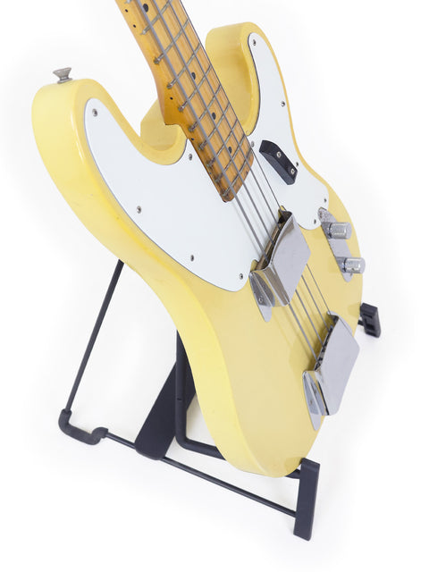 Vintage yellow Fender Telecaster Bass guitar from 1968, positioned on a stand.