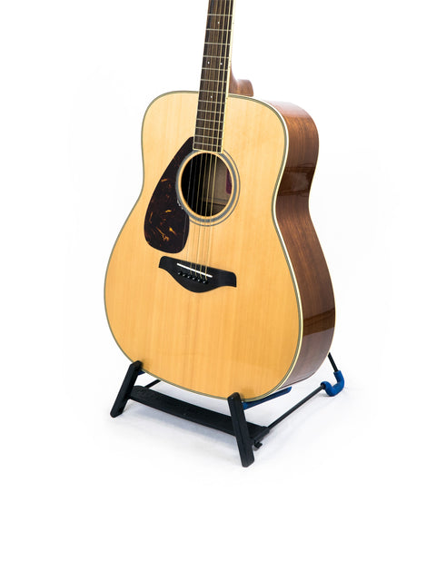 Yamaha FG 720 SL left-handed guitar on a stand, showcasing its design against a simple white backdrop.