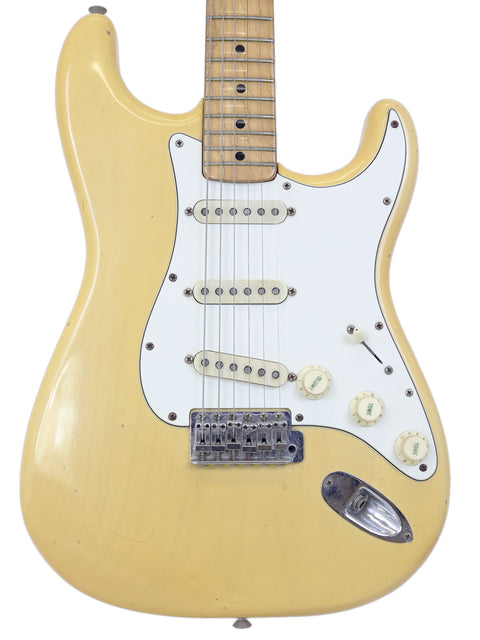 Yellow electric guitar with a white body, a vintage 1954 Fender Stratocaster, representing iconic American guitar design.