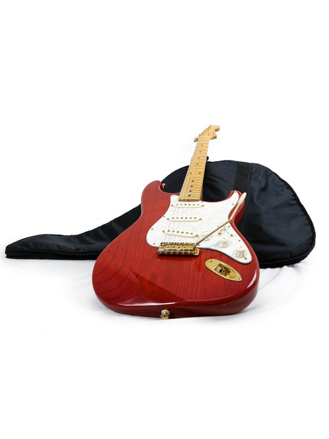 red Fender MIJ '57 Style Stratocaster guitar in a black case, set against a clean white background.