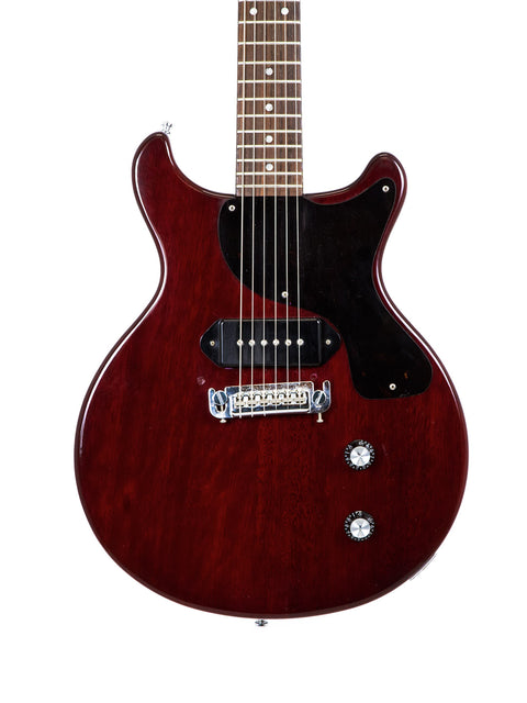 vibrant red electric guitar featuring a sleek black pickguard, representing the 1980s Burny "Rockin Roll Version" Les Paul Jr.