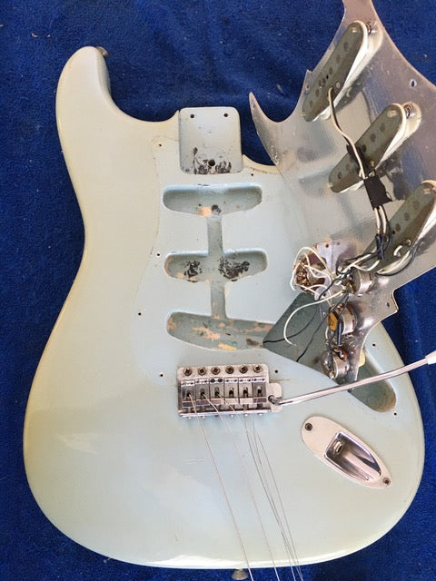 white 1972 Fender Stratocaster guitar with a broken neck and bridge, labeled as sold, showcasing its vintage charm.