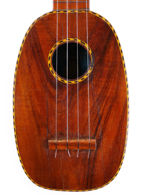 1. Vintage Kamaka Pineapple Style #3 Ukulele from 1928, featuring a wooden body and neck, showcasing classic craftsmanship.
