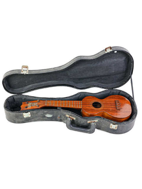 1920s Kumalae ukulele displayed in its case, set on a pristine white background for a classic look.