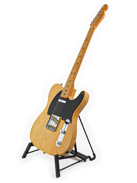 1982 Fender AVRI ‘52 Telecaster resting on a stand, showcasing its vintage charm against a white background.