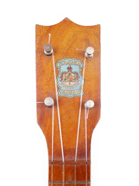 A 1928 Kamaka Pineapple Style #3 Ukulele adorned with a unique badge on its neck.