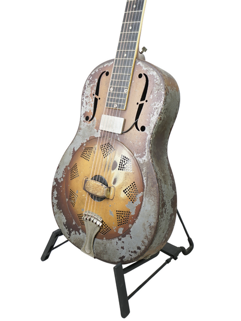 A 1930 National Triolian guitar with a rustic look, displayed on a sturdy metal stand, highlighting its vintage appeal.