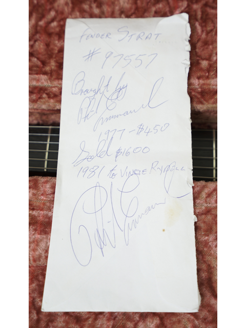 A 1963 Fender Stratocaster in Fiesta Red, autographed by band members, highlighting its unique vintage appeal.