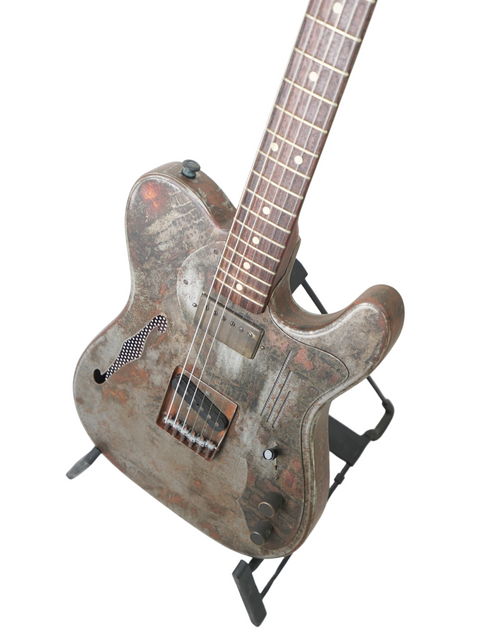 A 2006 James Trussart Steelcaster guitar with a rustic finish, elegantly positioned on a stand, emphasizing its unique features.
