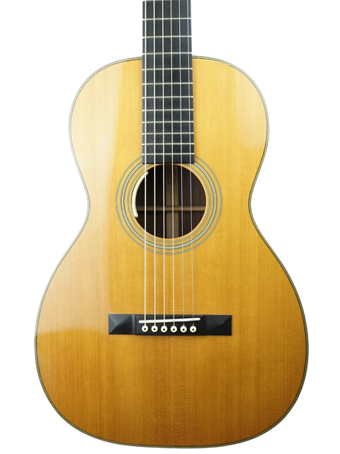 A 2011 Martin 0-28VS guitar rests on a white background, highlighting its classic shape and fine wood detailing.