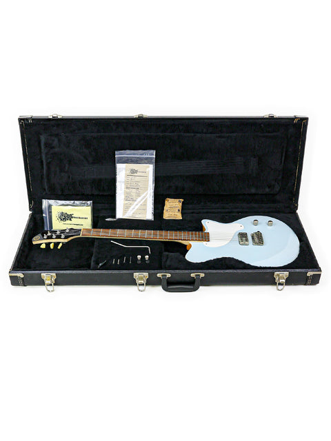 A 2013 USA Koll Troubadour guitar nestled in its case, surrounded by essential accessories for musicians.