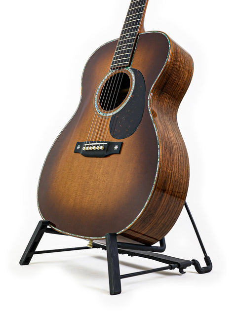A 2019 Martin Custom Shop 000-42 guitar in Guatemalan Rosewood, resting on a sleek black stand.