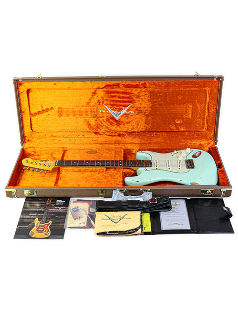 A Fender guitar, specifically the Yuriy Shishkov Master Built ‘59 Stratocaster Relic, housed in a case with accessories.