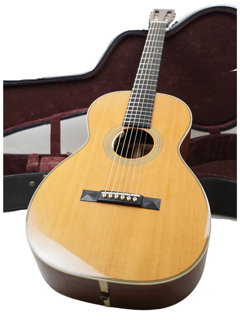 A Martin 0-28VS guitar with its case, set on a white background, emphasizing the beauty and detail of this USA-made instrument.