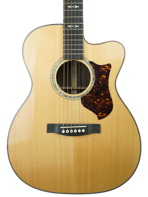 A Martin OMC-PA1 acoustic guitar from 2011 rests on a white background, showcasing its craftsmanship and beauty.
