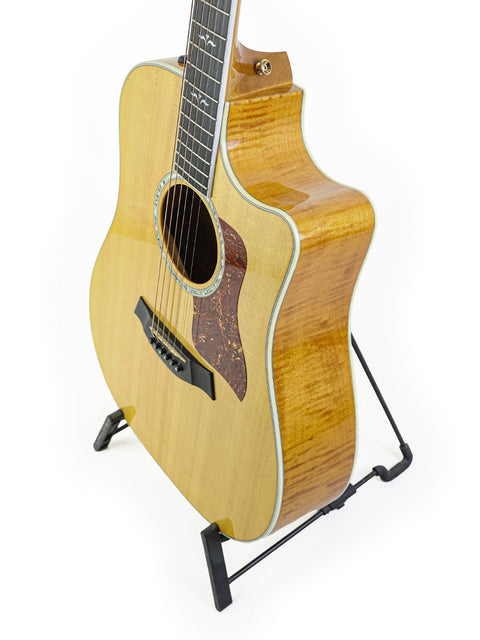 A Taylor 610CE guitar, made in 2003, displayed on a stand with a crisp white background.
